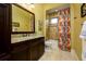 Bright bathroom with granite countertop vanity and a tub-shower with vibrant curtain at 2680 Keystone Springs Rd, Tarpon Springs, FL 34688