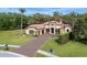 Elegant home boasts a paver driveway, manicured lawn, and stately palm trees on a sunny day at 2680 Keystone Springs Rd, Tarpon Springs, FL 34688