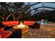 Screened-in lanai with a fire pit and comfortable seating is perfect for evening relaxation at 2680 Keystone Springs Rd, Tarpon Springs, FL 34688