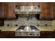 The kitchen features a stainless steel gas range with decorative backsplash and dark wood cabinets at 2680 Keystone Springs Rd, Tarpon Springs, FL 34688