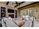A stylish living room with a stone fireplace, beamed ceilings, and access to outdoor patio space at 2680 Keystone Springs Rd, Tarpon Springs, FL 34688