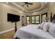 Luxurious primary bedroom features tray ceiling, fan, and scenic outdoor views at 2680 Keystone Springs Rd, Tarpon Springs, FL 34688