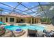 Resort-style pool features a waterfall, hot tub, sun shelf and screened-in lanai at 2680 Keystone Springs Rd, Tarpon Springs, FL 34688