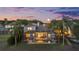 Real estate picture featuring a home with a screened pool at sunset surrounded by mature landscaping at 27338 Hollybrook Trl, Wesley Chapel, FL 33544