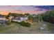 Home exterior view featuring screened-in pool and landscaped yard at sunset at 27338 Hollybrook Trl, Wesley Chapel, FL 33544