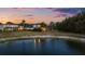 Home featuring a screened-in pool and a lush backyard with views of a serene pond at 27338 Hollybrook Trl, Wesley Chapel, FL 33544
