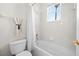 Well-lit bathroom with a shower-tub combo, a white curtain and a toilet at 27338 Hollybrook Trl, Wesley Chapel, FL 33544