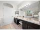Elegant bathroom featuring double sinks, vanity lighting, and a large mirror at 27338 Hollybrook Trl, Wesley Chapel, FL 33544