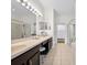 Bright bathroom featuring a long vanity with double sinks, mirrors and tiled floors at 27338 Hollybrook Trl, Wesley Chapel, FL 33544