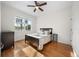 Bedroom with wood floors, ceiling fan, and a window offering a view at 27338 Hollybrook Trl, Wesley Chapel, FL 33544