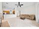 Spacious living room with connected kitchen, tile floors, a ceiling fan, and abundant light at 27338 Hollybrook Trl, Wesley Chapel, FL 33544
