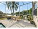 Screened patio boasts outdoor seating area with beautiful views of the yard and pond at 27338 Hollybrook Trl, Wesley Chapel, FL 33544