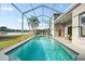 Sparkling pool with screened enclosure, a lake view, and manicured lawn at 27338 Hollybrook Trl, Wesley Chapel, FL 33544