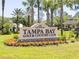 Entrance sign for Tampa Bay Golf & Country Club with lush landscaping and towering palm trees at 29432 Coharie Loop, San Antonio, FL 33576