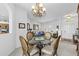 Elegant dining area with a glass table, chandelier, and view into the living room at 29432 Coharie Loop, San Antonio, FL 33576