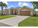 Charming one-story home with a well-manicured lawn, concrete driveway, and a two-car garage at 29432 Coharie Loop, San Antonio, FL 33576