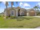 Charming single-story home featuring lush landscaping and inviting curb appeal with a tan exterior at 29432 Coharie Loop, San Antonio, FL 33576