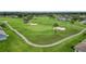 Aerial view of lush golf course fairway surrounded by pond, sand traps and winding paths at 29432 Coharie Loop, San Antonio, FL 33576