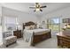 Comfortable primary bedroom with a ceiling fan, natural light, and a serene water view at 29432 Coharie Loop, San Antonio, FL 33576