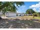 Large backyard view featuring concrete patio and mature trees, providing a serene outdoor space at 324 Country Club Dr, Oldsmar, FL 34677