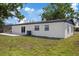 Angle shot of the house showing a small patio, backyard, and exterior details at 324 Country Club Dr, Oldsmar, FL 34677