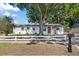 Charming home featuring a spacious front yard with a large tree and a classic white picket fence at 324 Country Club Dr, Oldsmar, FL 34677