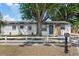 Charming home featuring a spacious front yard with a large tree and a classic white picket fence at 324 Country Club Dr, Oldsmar, FL 34677