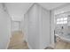 Hallway with closets and bathroom featuring marble walls and glass shower at 324 Country Club Dr, Oldsmar, FL 34677