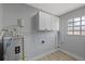 Utility room with white cabinets and new tank-style water heater at 324 Country Club Dr, Oldsmar, FL 34677