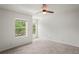 Bright bedroom featuring neutral carpet, white walls, ceiling fan, and sunlit windows at 3437 Dragon View Ct, Valrico, FL 33594