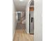 Hallway with a blend of modern flooring, plush carpeting leading to stairs, and stainless steel refrigerator at 3437 Dragon View Ct, Valrico, FL 33594