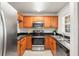 Well-lit kitchen featuring oak cabinets, stainless steel appliances, granite countertops, and modern flooring at 3437 Dragon View Ct, Valrico, FL 33594