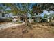 Charming home featuring a light green exterior, wooden pergola and a mature tree in front at 3962 Poinsettia Dr, St Pete Beach, FL 33706