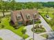 Aerial view of a brick two-story home with a circular driveway, mature landscaping, and golf course views at 4033 Priory Cir, Tampa, FL 33618