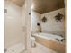 Bathroom with a glass shower, soaking tub, decorative light fixtures, and neutral wall decor at 4033 Priory Cir, Tampa, FL 33618