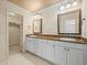 Bathroom featuring double sinks, granite counters, and wallpaper at 4033 Priory Cir, Tampa, FL 33618