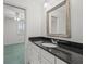 Bathroom featuring granite counters, white cabinets, a chrome faucet and framed mirror at 4033 Priory Cir, Tampa, FL 33618