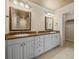 Bathroom featuring a double vanity with granite countertop, framed mirrors, and white cabinetry at 4033 Priory Cir, Tampa, FL 33618