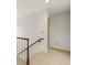 Carpeted hallway with wooden railing and a neutral color scheme at 4033 Priory Cir, Tampa, FL 33618