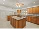 Spacious kitchen featuring granite counters, a central island cooktop, and tile flooring at 4033 Priory Cir, Tampa, FL 33618