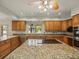 Charming kitchen features granite countertops, stainless steel appliances, and a central island cooktop at 4033 Priory Cir, Tampa, FL 33618