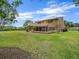 A view of a brick home featuring a screened-in porch, a balcony and a lawn at 4033 Priory Cir, Tampa, FL 33618