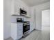 Bright kitchen featuring white cabinets, stainless steel appliances, and modern tile floors at 4519 5Th S Ave, St Petersburg, FL 33711