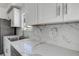 Modern kitchen with stainless steel sink, white marble countertops, and backsplash at 4519 5Th S Ave, St Petersburg, FL 33711