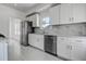 Well-lit kitchen with stainless steel appliances, white cabinets, and marble-style backsplash at 4519 5Th S Ave, St Petersburg, FL 33711