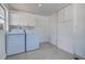 Laundry room featuring a washer and dryer, cabinets, and gray tile flooring at 4519 5Th S Ave, St Petersburg, FL 33711