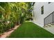 Lush backyard featuring artificial turf, tropical landscaping, and a serene ambiance for relaxation and entertainment at 4804 W Beachway Dr, Tampa, FL 33609