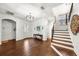 Bright foyer with hardwood floors, a chandelier, and staircase with wood treads and wrought iron railing at 4804 W Beachway Dr, Tampa, FL 33609