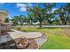 Expansive backyard with lush green grass, mature trees, a circular patio and white fencing at 505 S Larry Cir, Brandon, FL 33511