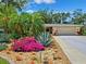 Beautiful front yard with colorful flowers, palm trees, and a well-maintained lawn at 505 S Larry Cir, Brandon, FL 33511